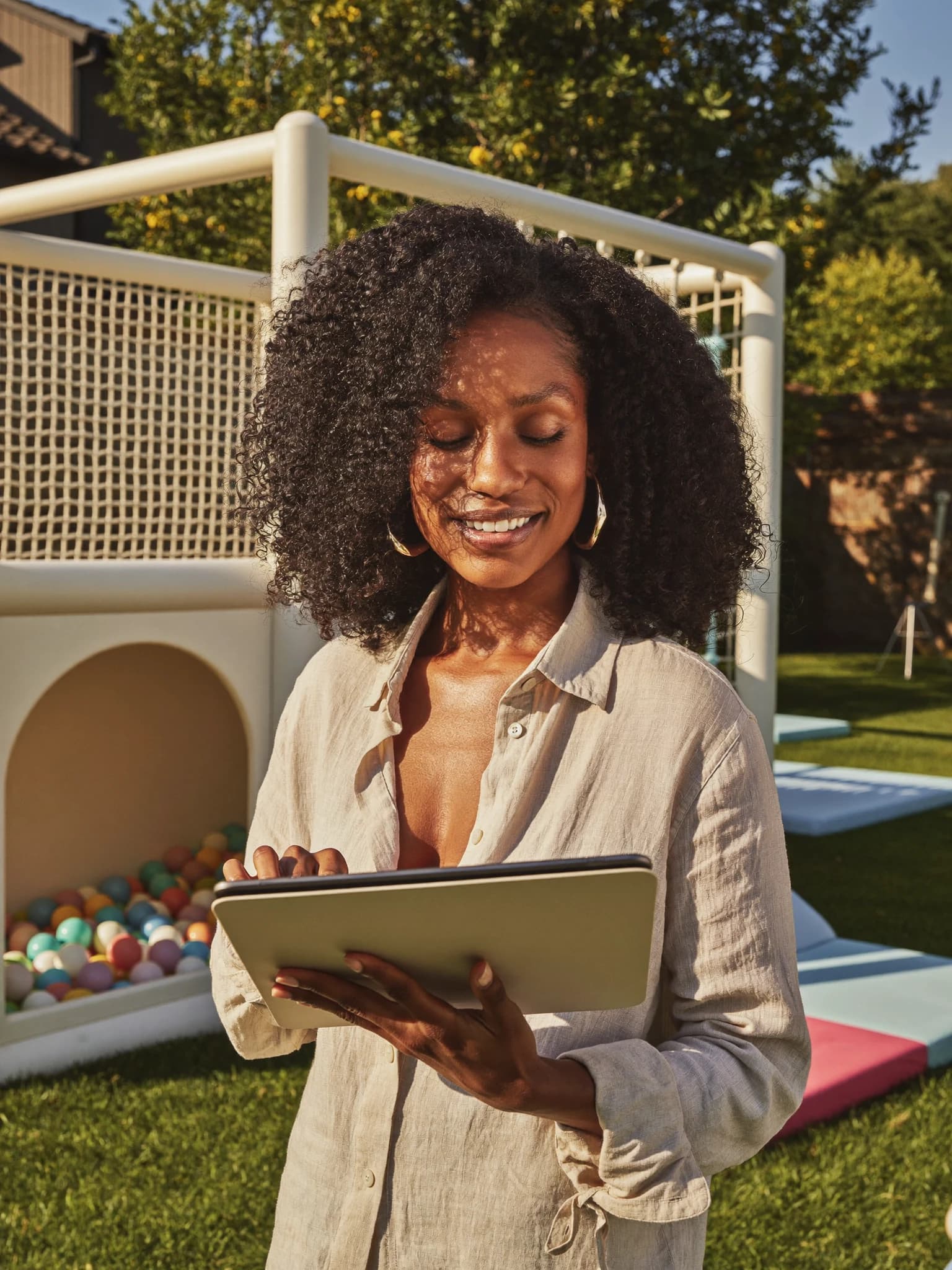 A soft play rental owner smiling while checking bookings on her tablet